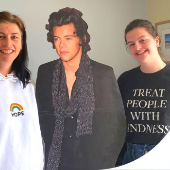 A picture of a mother and daughter posing with a cardboard cutout of Harry Styles